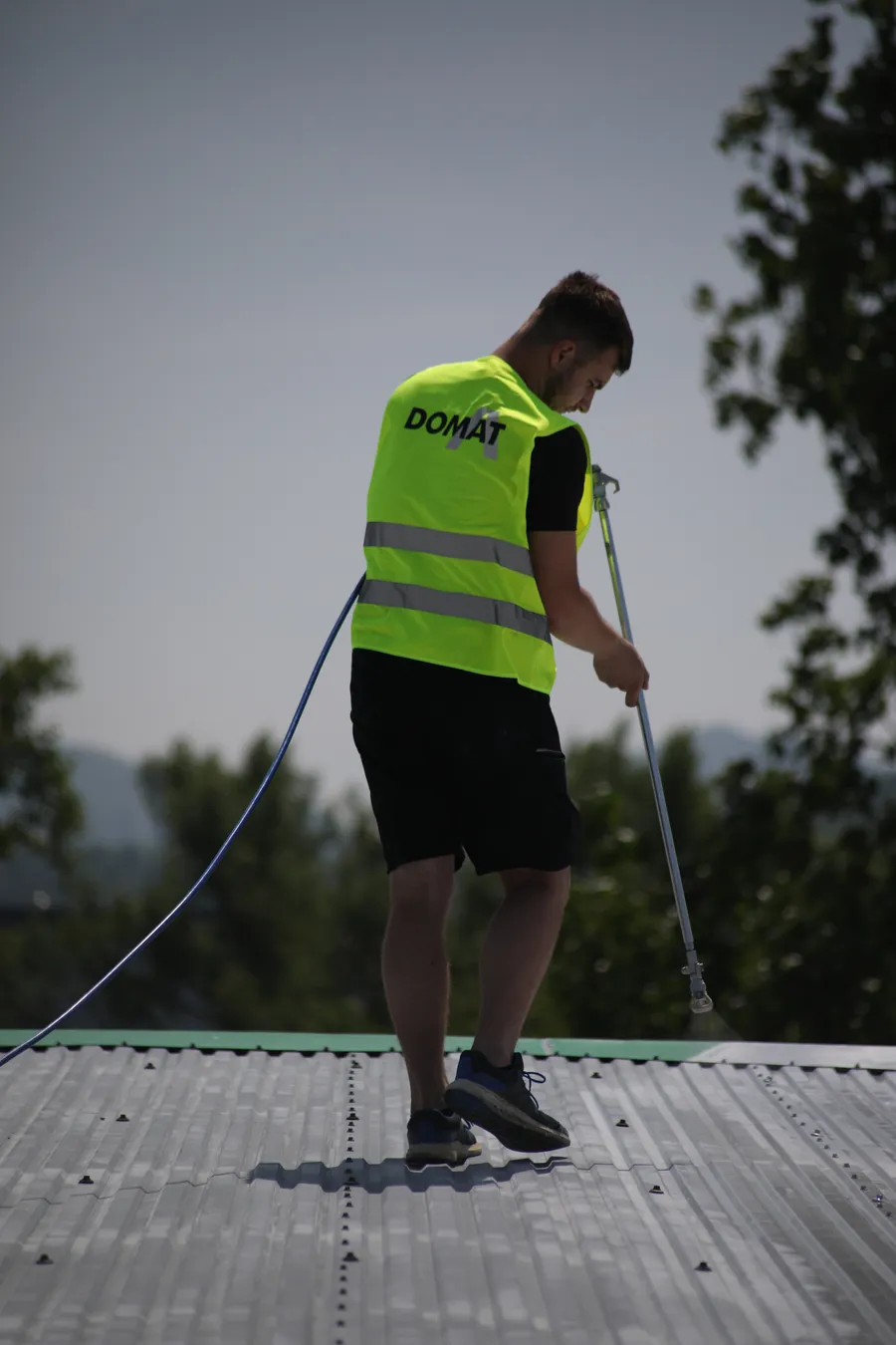Pracovník v reflexnej veste DOMAT počas montáže na streche